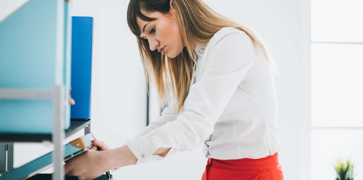 Receptionist using filing cabinet