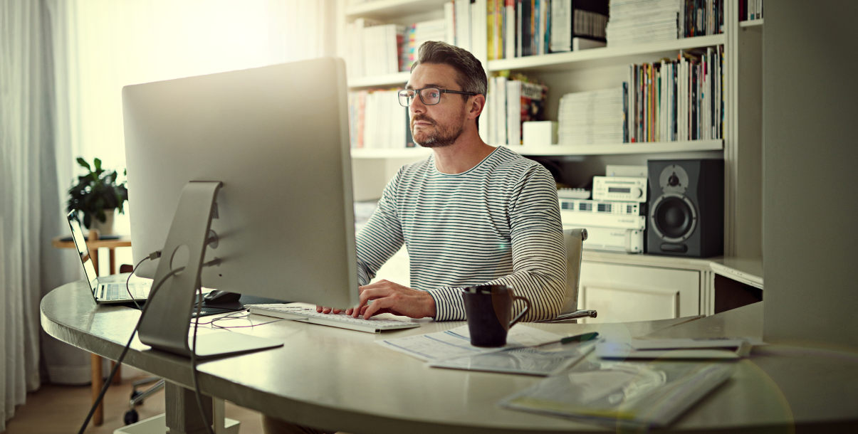 Man working at desk in home office.