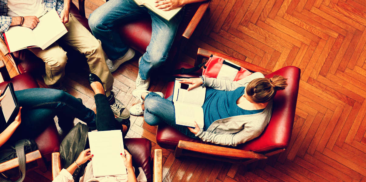 Overhead shot of coworkers collaborating on leather armchairs.