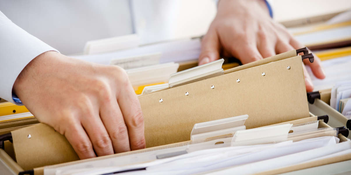 Hands browsing through a tidy filing system