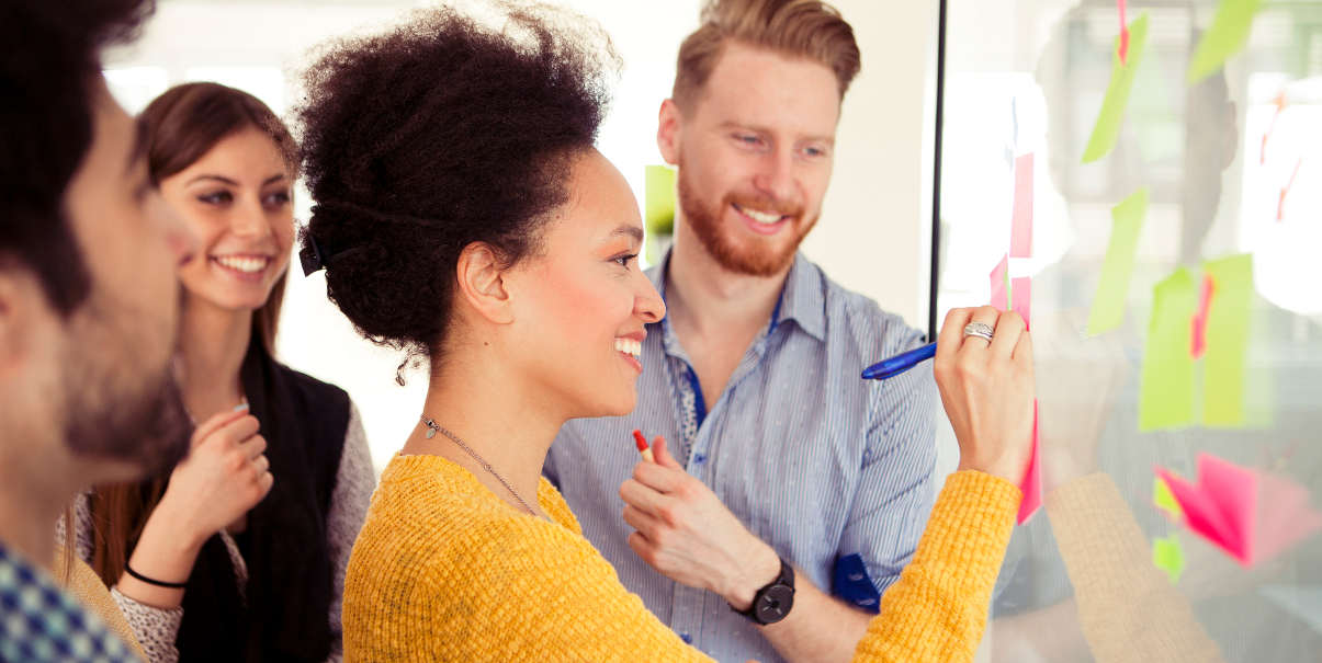 Coworkers sharing creative ideas on a glass wall