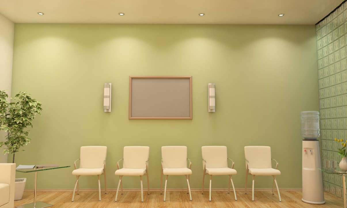 Minimalist waiting room with green walls and white chairs