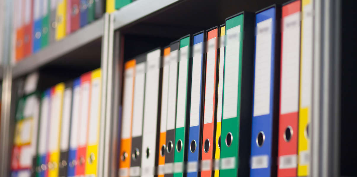 Rows of colorful folders on metal shelving.