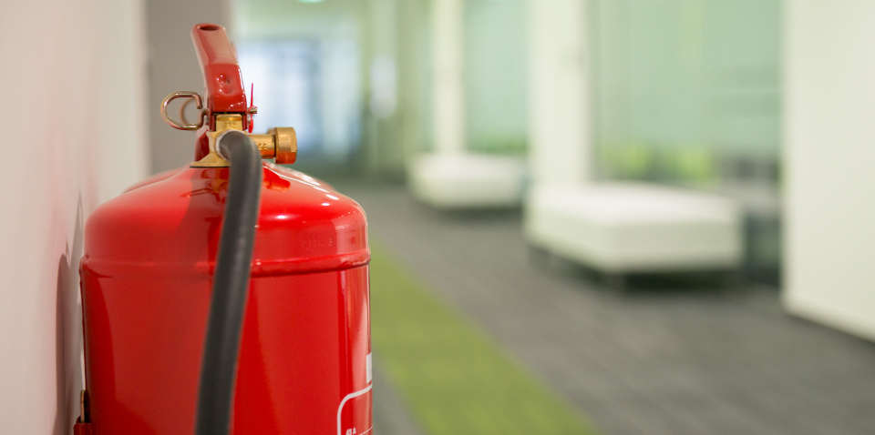 Office hallway with wall-mounted fire extinguisher.